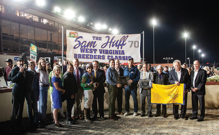 bob huff is presenting the trophy to owner eric steinman