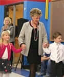 Gayle Manchin holding hands with two children