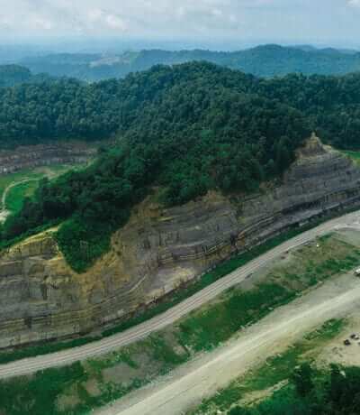 Arial view of a mountain with a road winding around it.