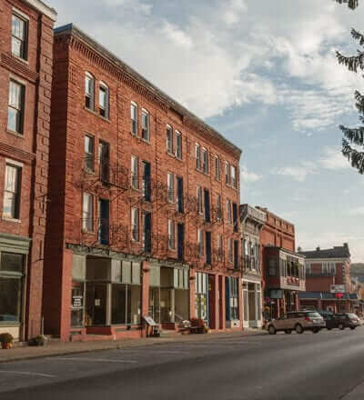 Brick buildings with stores on the bottom level and parking spots lines up in front of them