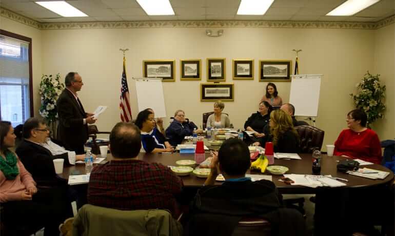 Community gathering around a table discussing how to turn their town around